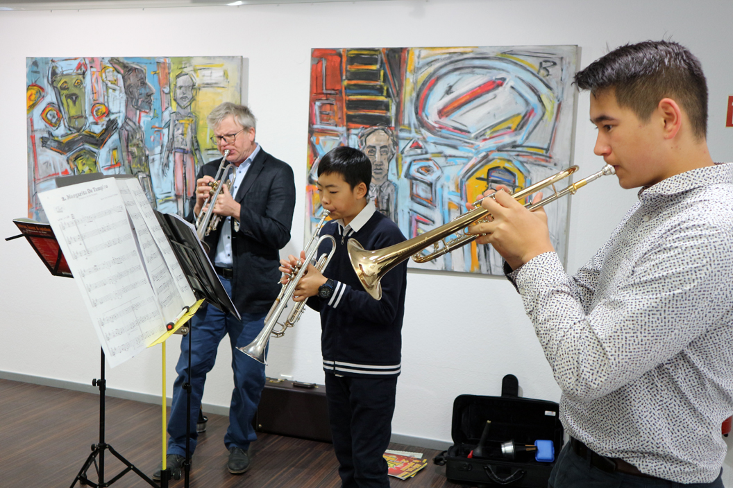 Norbert Niederer, Dozent an der Musikschule Filderstadt (FILUM), und seine Schüler Mathis Wang und Adrian Jöchner spielen für die Vernissagengäste auf der Trompete.